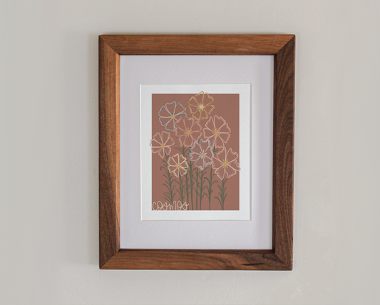 An art print line drawing of cosmos in bloom in a cherry hardwood frame