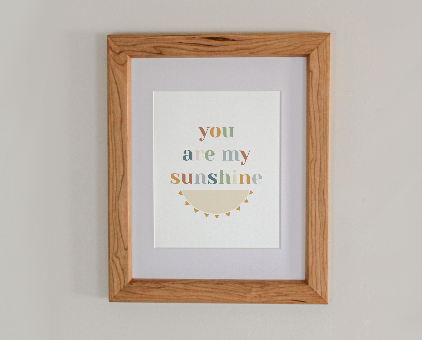 Art print of the text 'you are my sunshine' above the bottom half of an illustrated sun