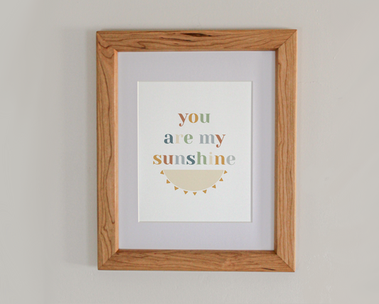 Art print of the text 'you are my sunshine' above the bottom half of an illustrated sun