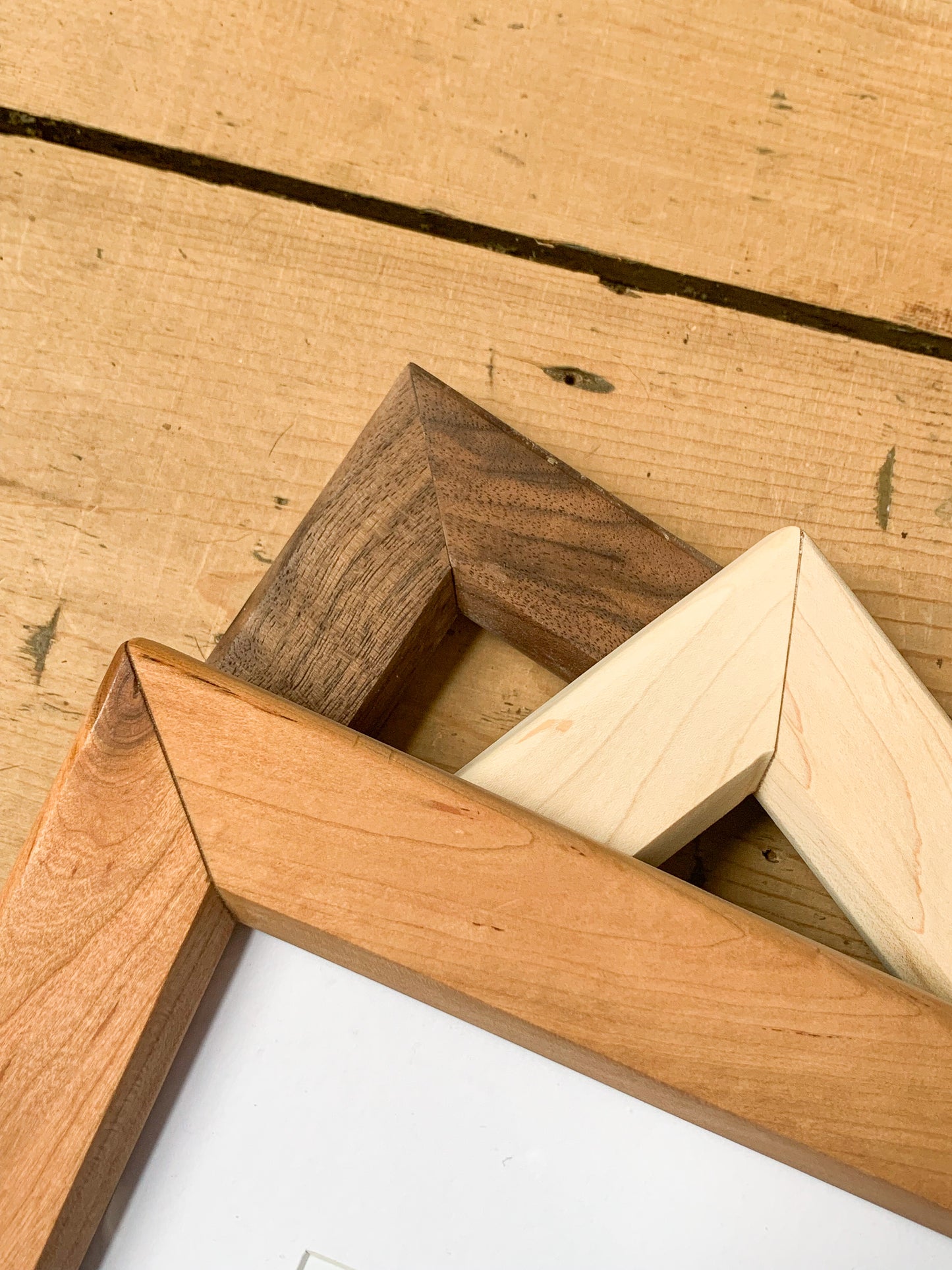 A flat lay of Stillbay Home Goods' hardwood frames in cherry, maple and black walnut