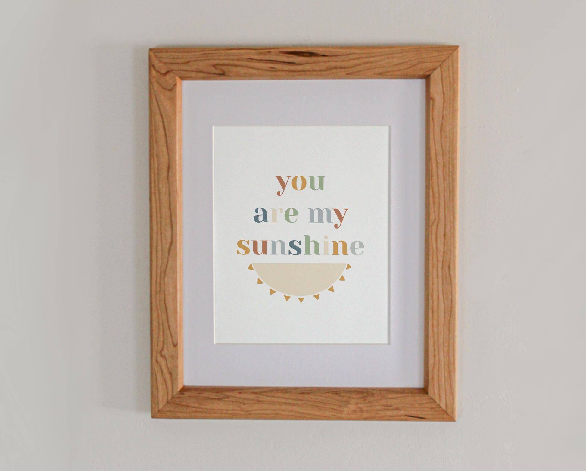 Art print of the text 'you are my sunshine' above the bottom half of an illustrated sun
