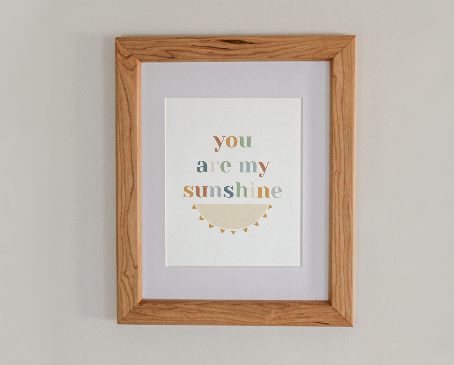 Art print of the text 'you are my sunshine' above the bottom half of an illustrated sun